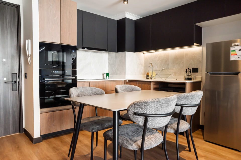 Modern kitchen with sleek appliances and cozy dining area, perfect for enjoying home-cooked meals.