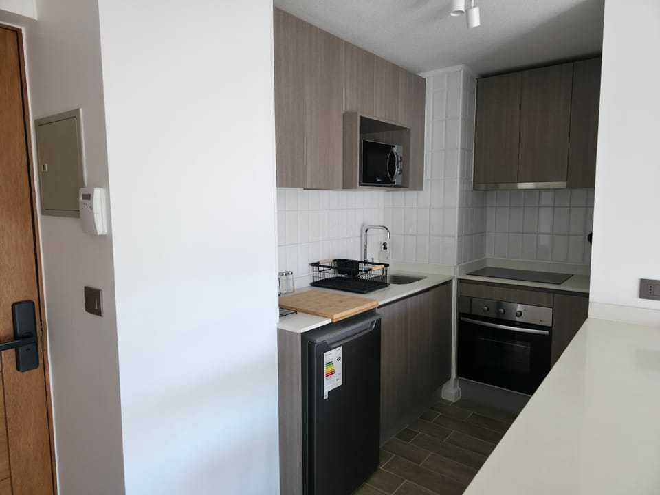 Sleek and modern kitchen with all essentials for a cozy stay in this efficient studio apartment.