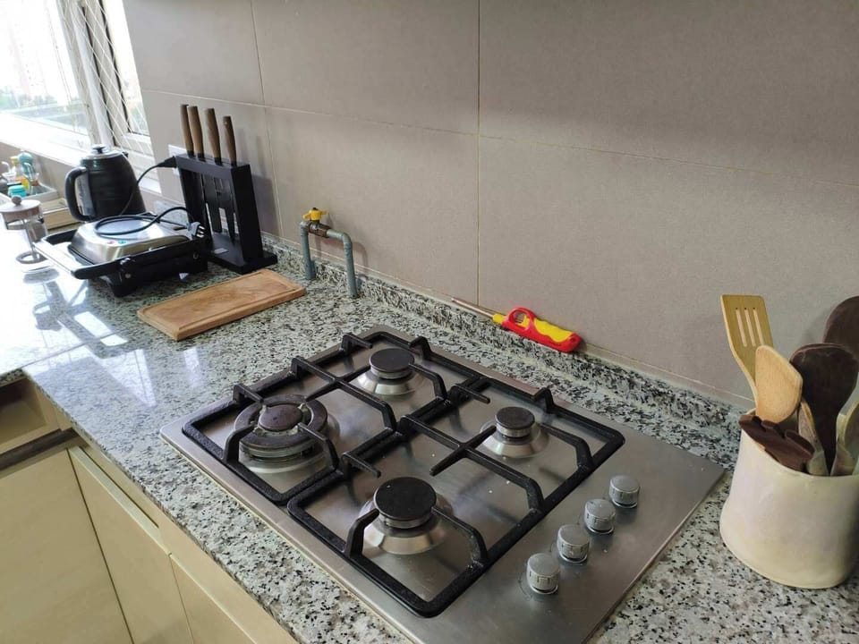 Modern kitchen with granite countertops and a four-burner stove, perfect for cooking enthusiasts.
