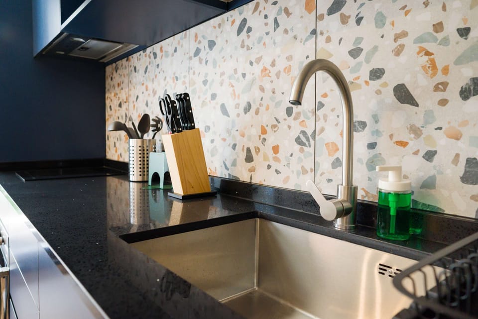 Sleek kitchen with terrazzo backsplash and modern fixtures, ideal for culinary exploration.