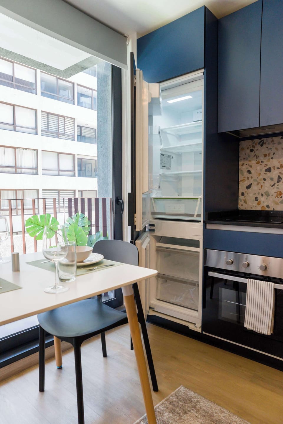 Bright and modern kitchen with sleek appliances and a cozy dining area, perfect for intimate meals.