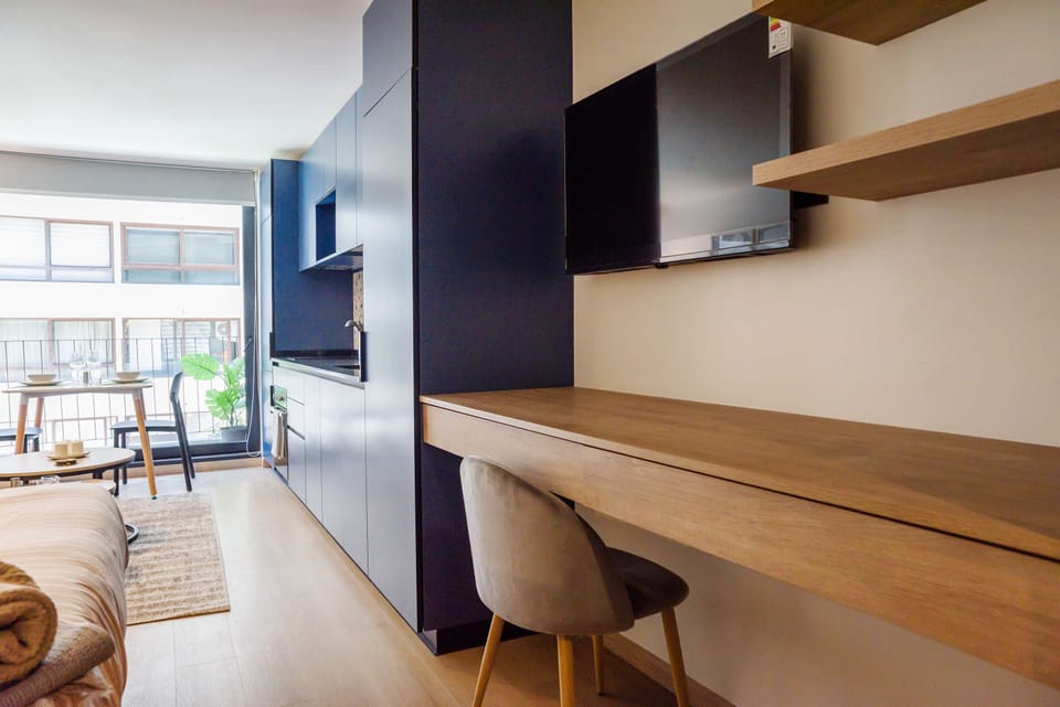 Bright and modern studio with sleek kitchen, cozy dining area, and workspace, ideal for city stays.