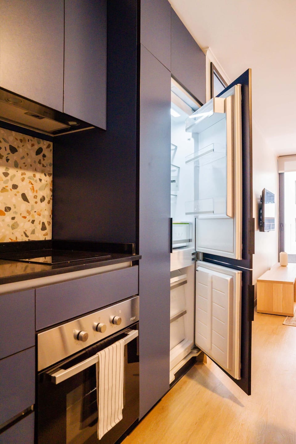 Experience culinary delight in this sleek kitchen with terrazzo accents and modern appliances.