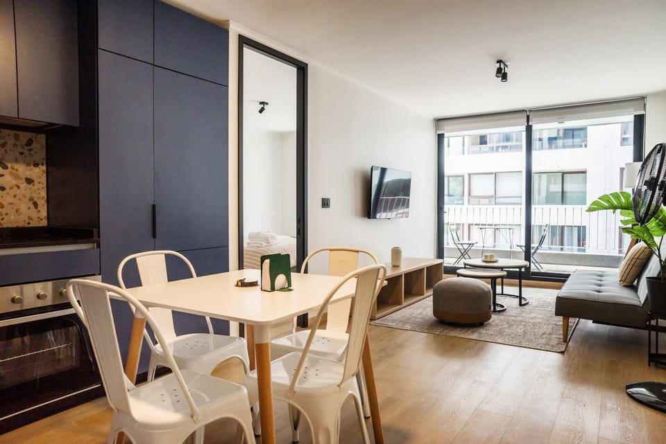 Bright and modern living space with a cozy seating area and balcony access, perfect for relaxation and dining.