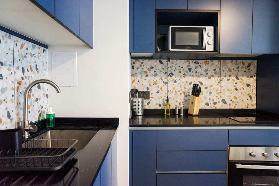 Sleek and modern kitchen with stylish terrazzo backsplash and all essentials for a comfortable stay.