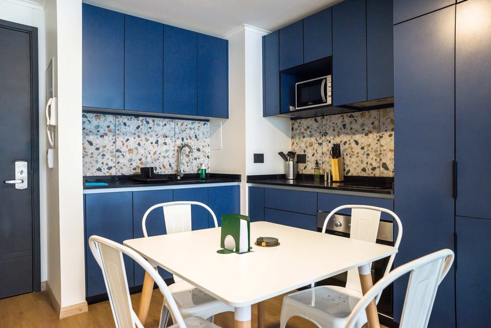 Modern kitchen with stylish blue cabinets and terrazzo backsplash, perfect for cozy dining and cooking.