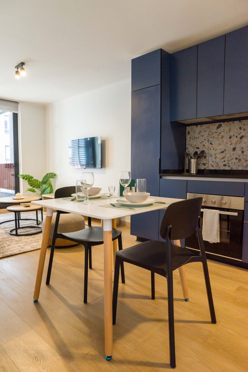 Modern dining area with sleek kitchen and stylish decor, perfect for cozy meals in a chic setting.