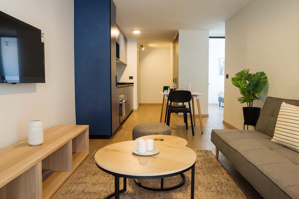 Modern living area with cozy seating, sleek kitchenette, and dining space, perfect for city explorers.