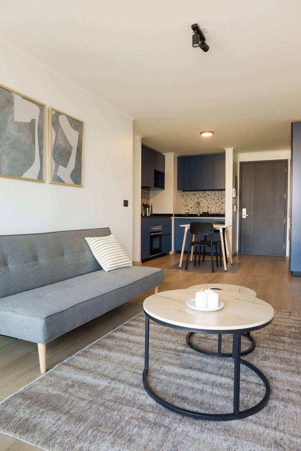 Cozy living area with stylish decor and a compact kitchen, perfect for a city getaway.