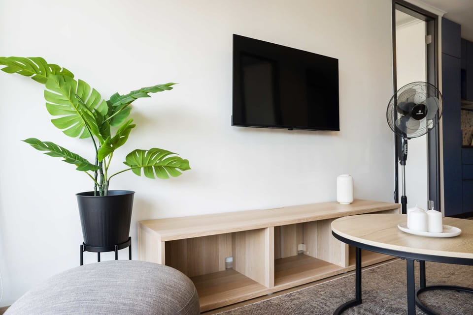 Relax in this cozy living area with a sleek TV setup and lush greenery, perfect for unwinding after a day of exploring.