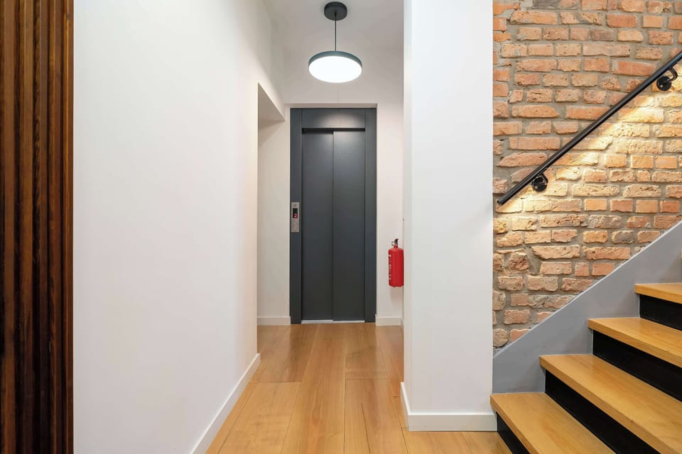 Staircase area combining brick, wood, and modern lighting.
