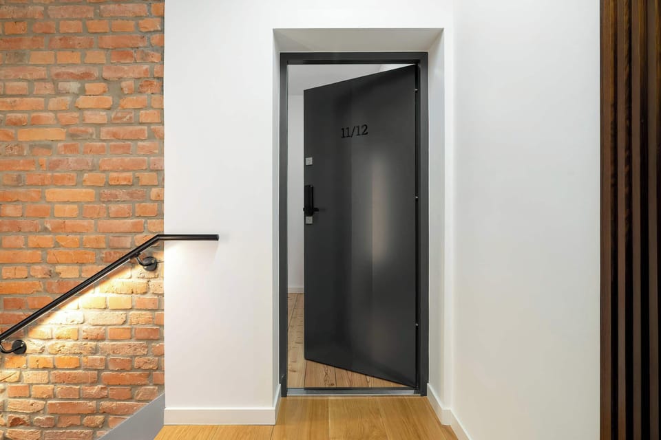 Entrance to the apartment from a corridor with exposed brickwork.