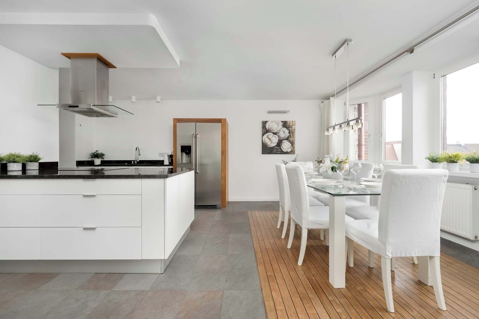 A modern kitchen featuring white cabinets, a kitchen island, and stainless steel appliances.