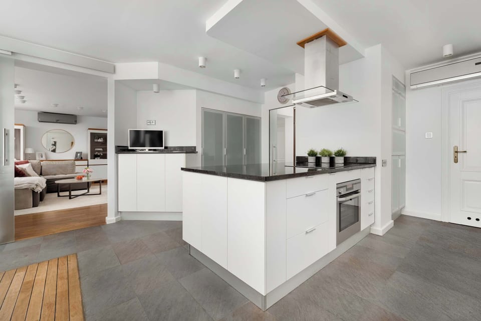 A sleek kitchen with contemporary appliances, minimalist design, and white cabinetry.