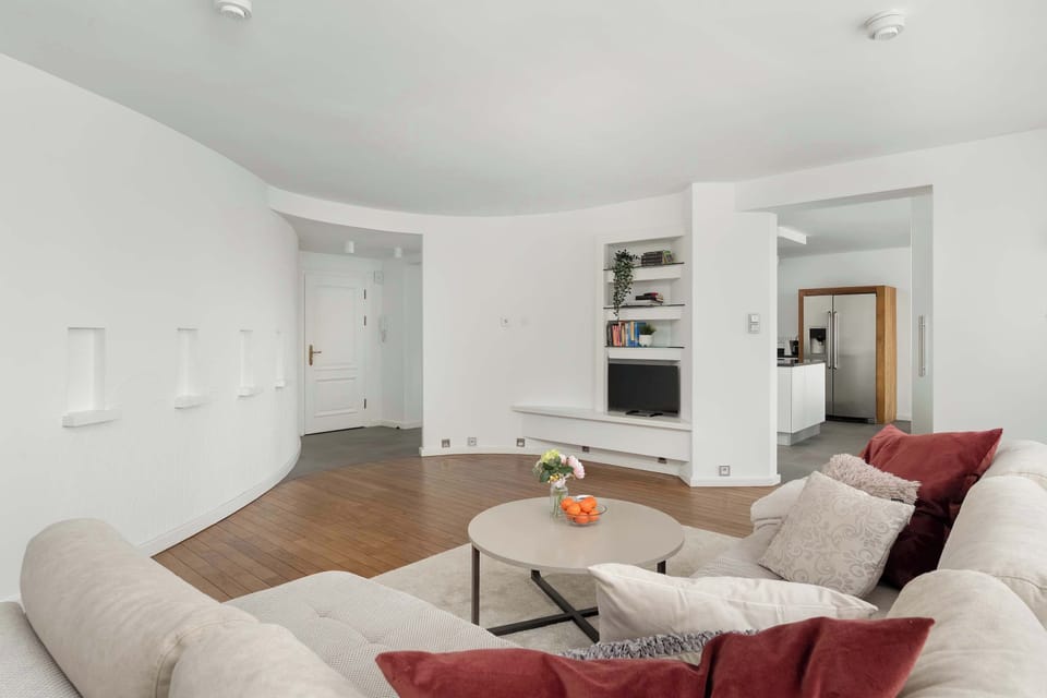 A comfortable sofa in light upholstery is set in the central area, next to which is a delicate coffee table.