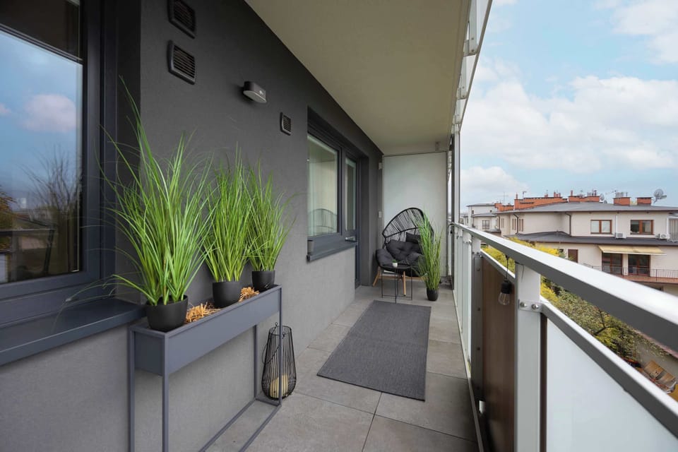 The balcony with green plants and a city view is the perfect spot for a morning coffee in the open air.