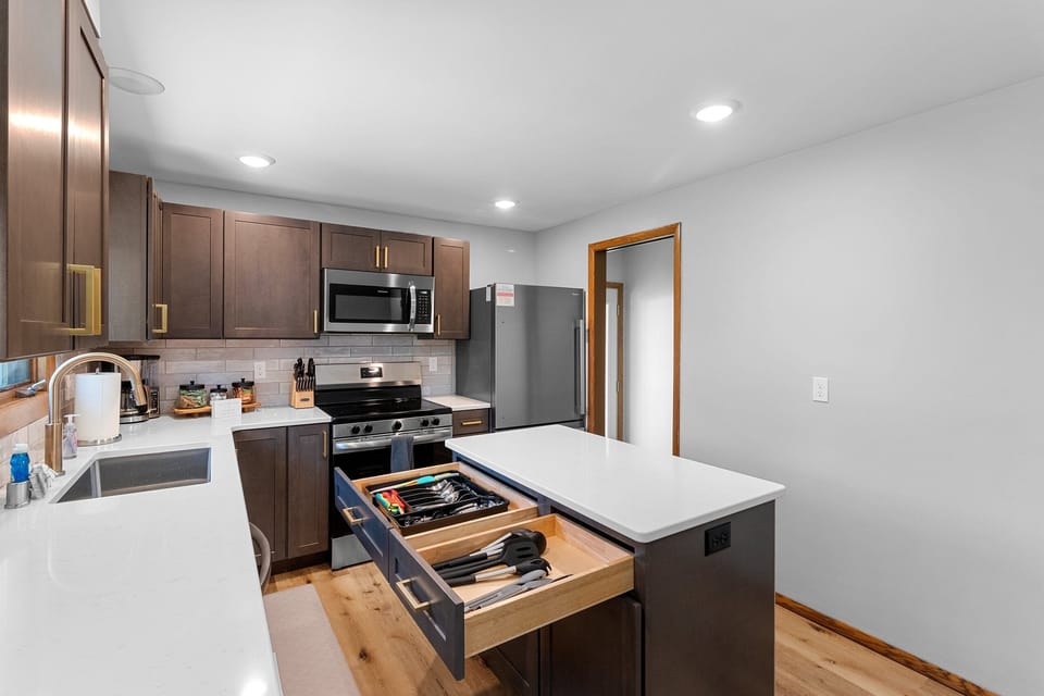 Modern kitchen with island, stainless appliances, and bright finishes