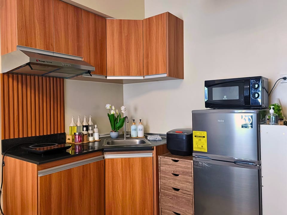 Modern kitchenette with sleek cabinets & all essentials for a comfy stay.