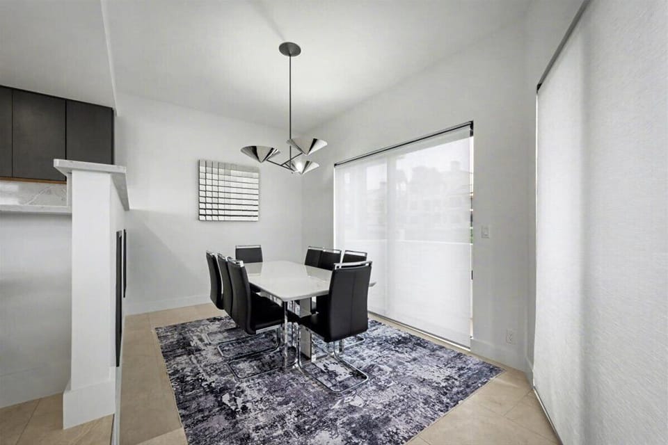 Your modern dining area features sleek black chairs around a stylish white table, perfect for memorable meals together.