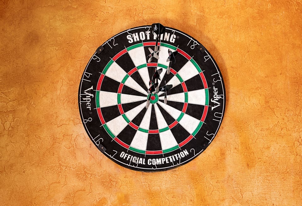 Challenge your aim and enjoy some friendly competition with this classic wall-mounted dartboard set against warm textured walls.
