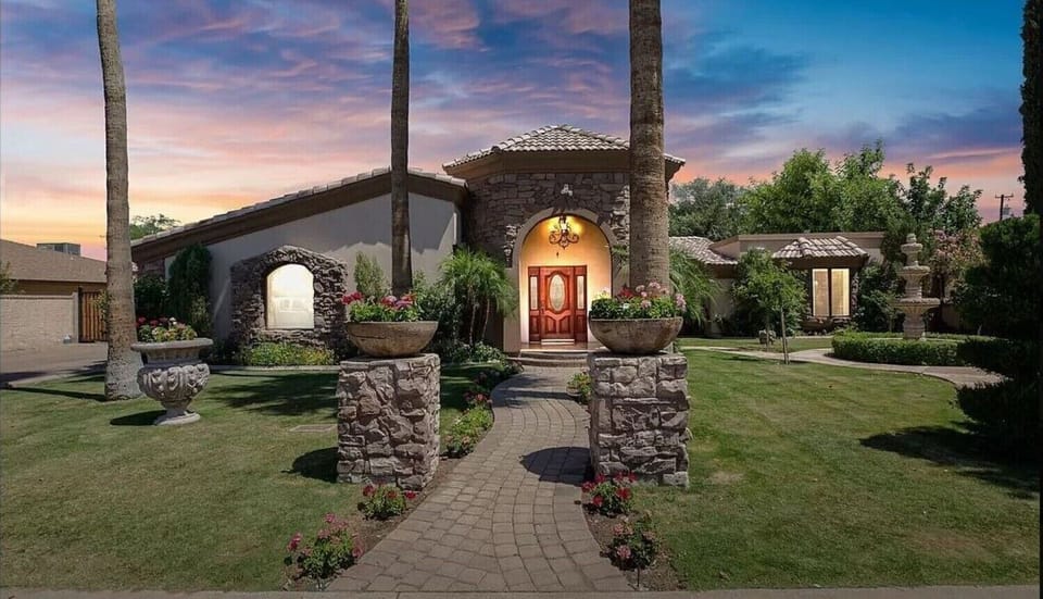 Step into your private oasis, a stone-accented haven surrounded by lush gardens, glowing sunsets, and a grand entrance that warmly welcomes you home.