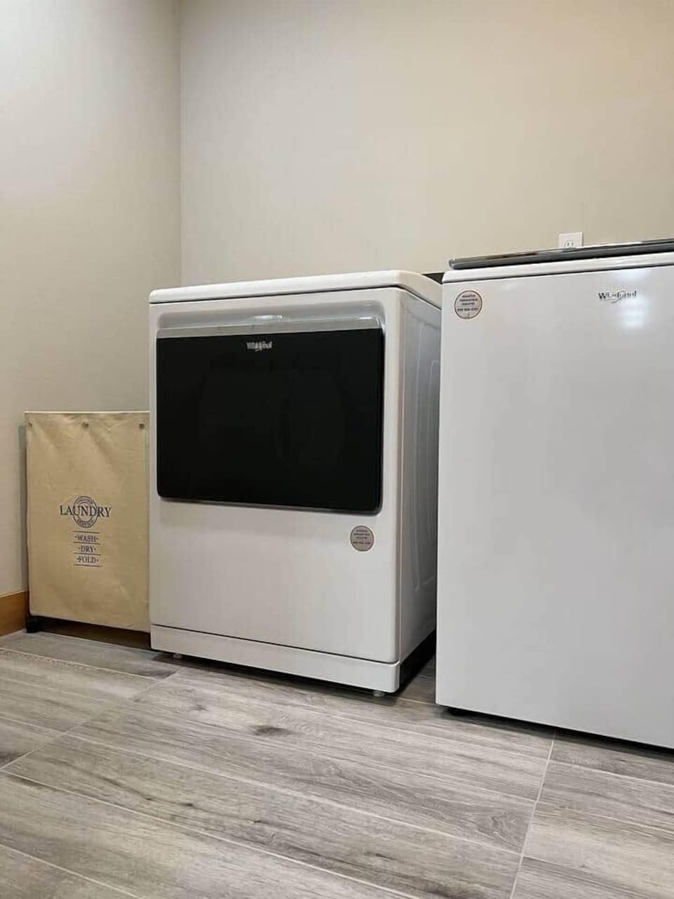 Enjoy the convenience of this laundry room: equipped with a high-capacity washer and dryer, plus a handy laundry bin, this clean and modern space ensures your clothes are fresh with ease. Perfect for extended stays on warm wooden floors!