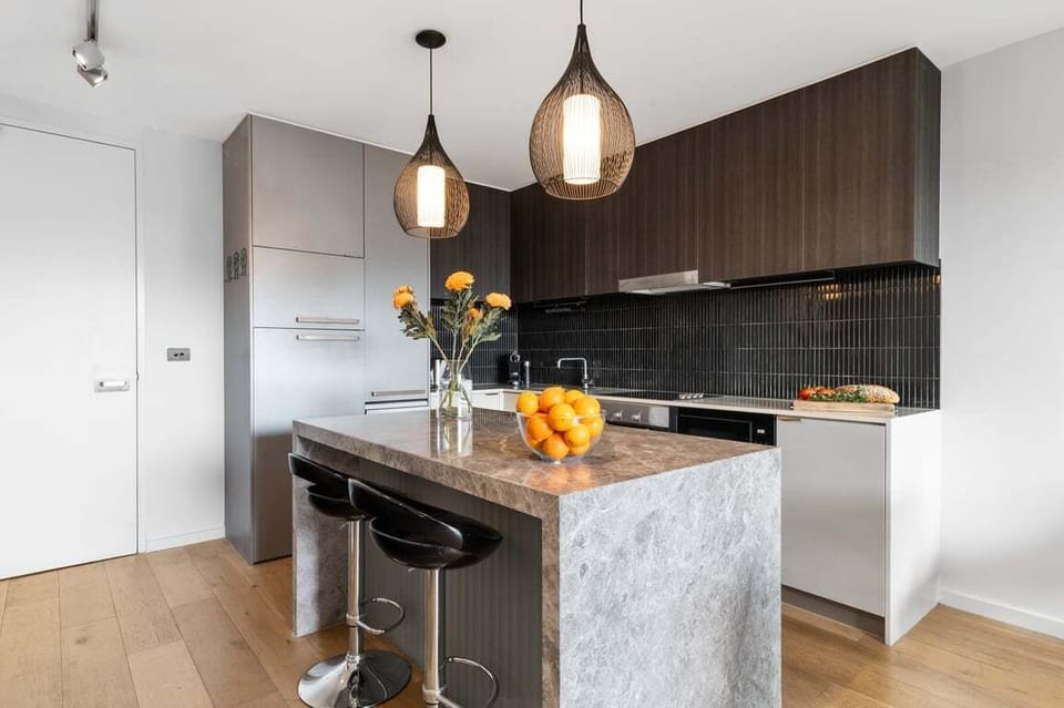 KITCHEN: Designer kitchen with Tundra Grey Stone island bench. Quality Bosch & Omega stainless steel appliances. Stylish integrated fridge.