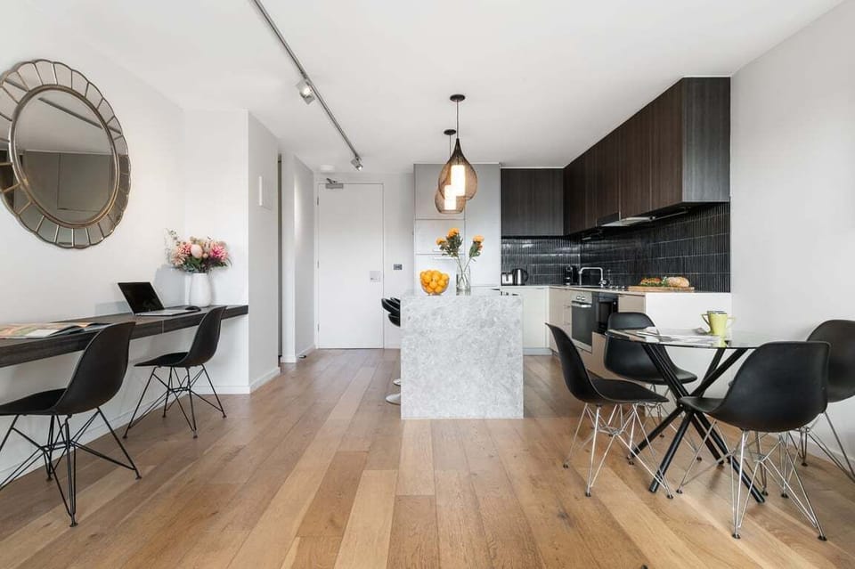 OPEN PLAN: Workstation desk, dining table that seats four and a stylish modem kitchen.