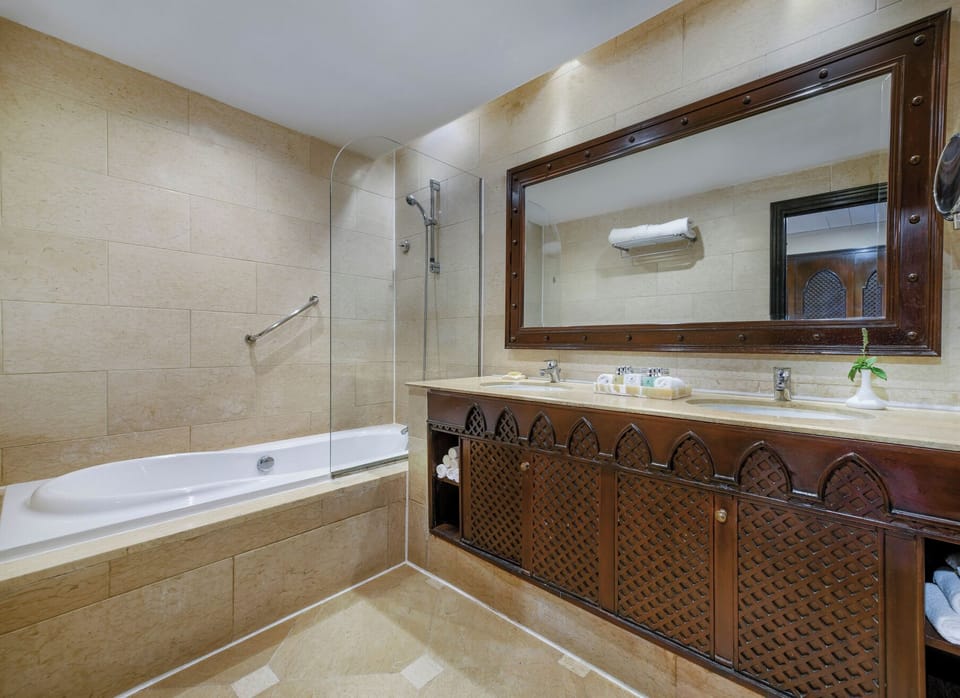 Refresh in a spacious bath with elegant vanity and lighting.
