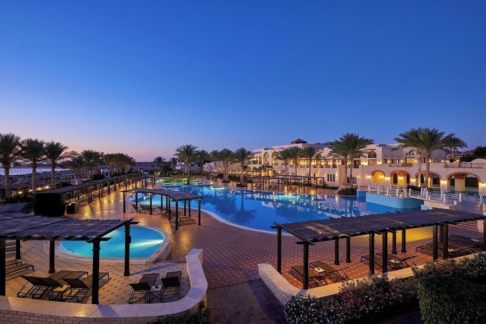 Sip something cool as the pool glows under evening skies.