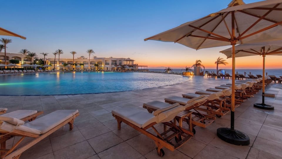 Unwind at sunset beside the infinity pool and loungers.