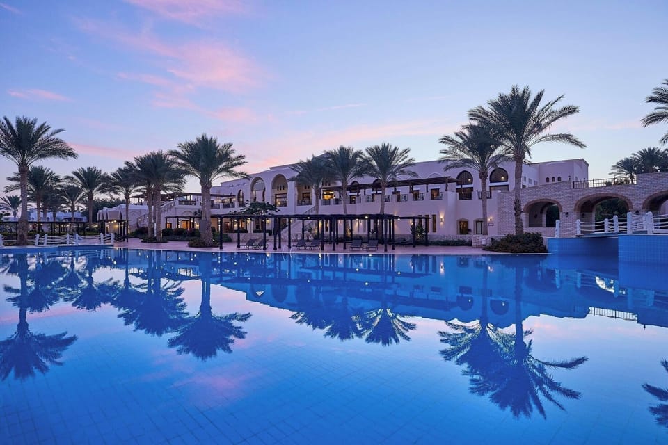 Soak in serene twilight reflections across the resort’s grand arches.
