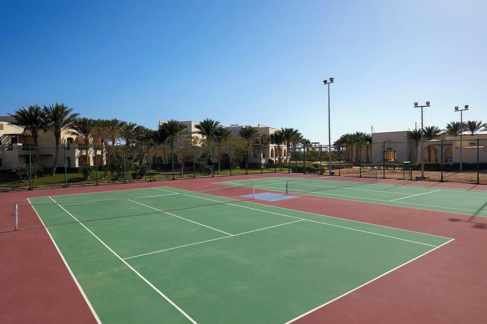 Serve up a match on pristine courts under blue skies.