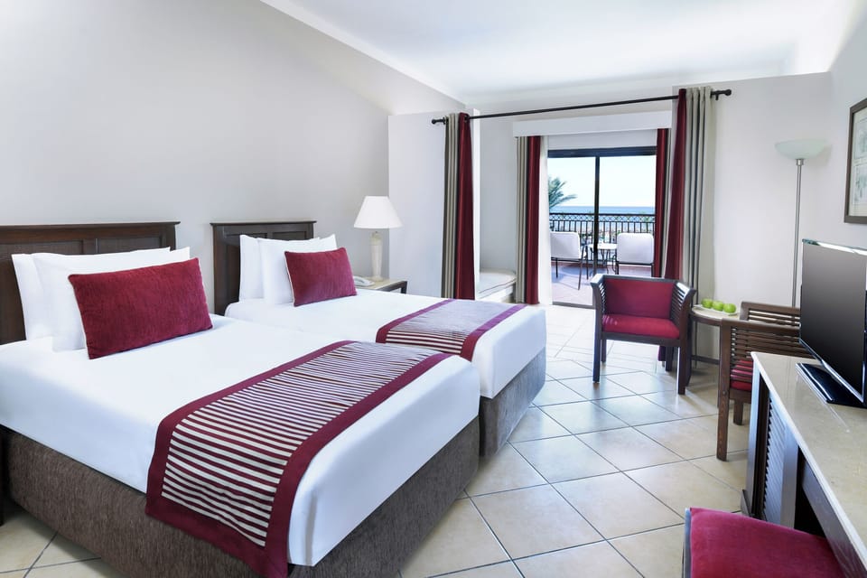 Drift off in bright twin beds beside the balcony doors.