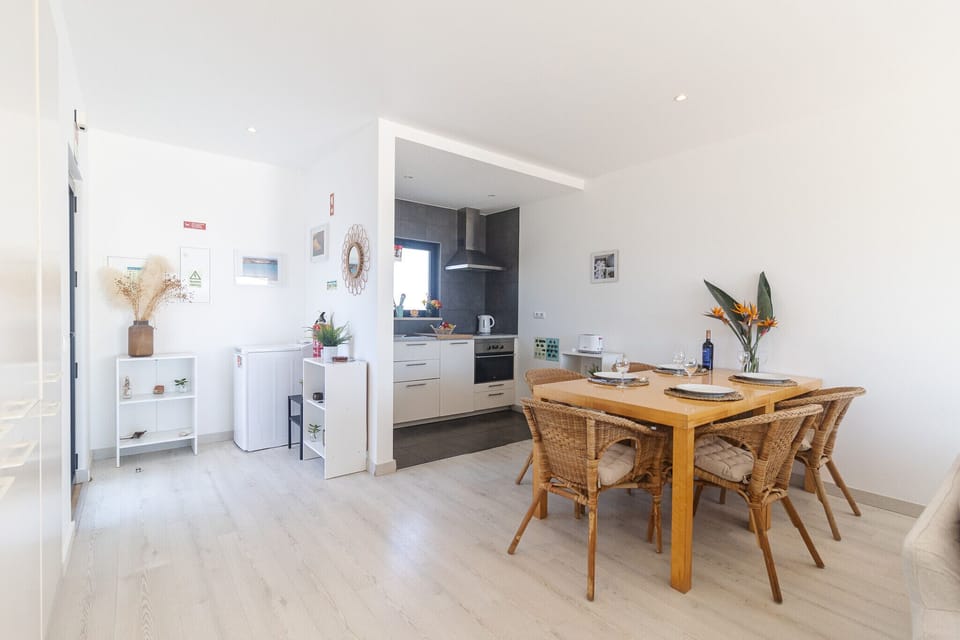 Bright open-plan kitchen and dining area with wooden table — Villa Infante, holiday villa in Vila do Bispo