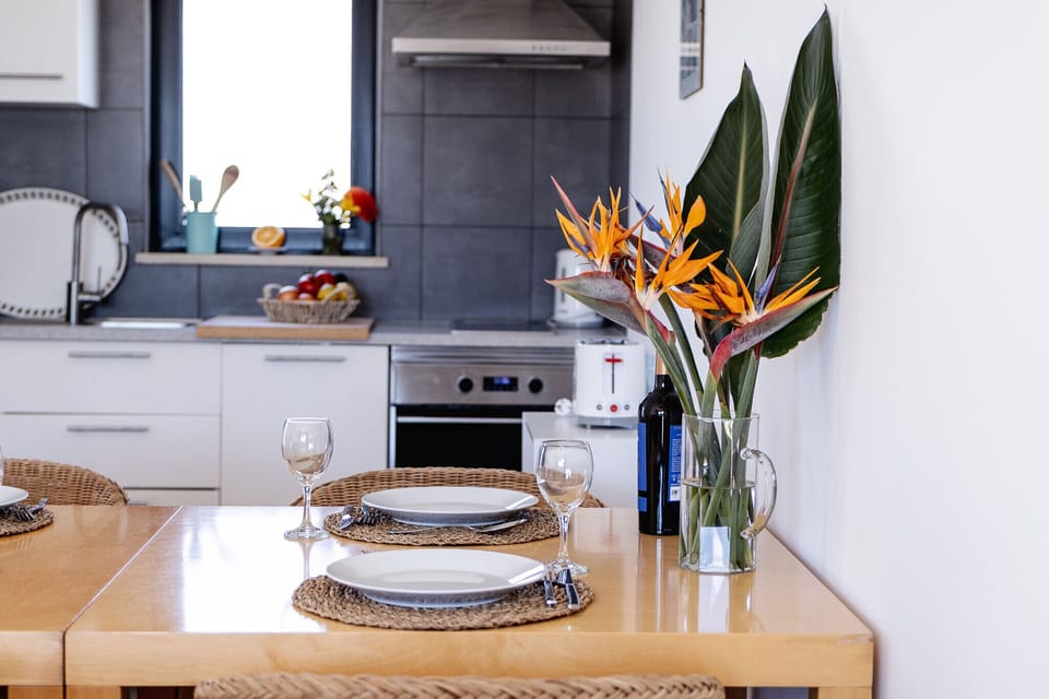 Modern kitchen and dining area with bird of paradise flowers — Villa Infante, holiday villa in Vila do Bispo
