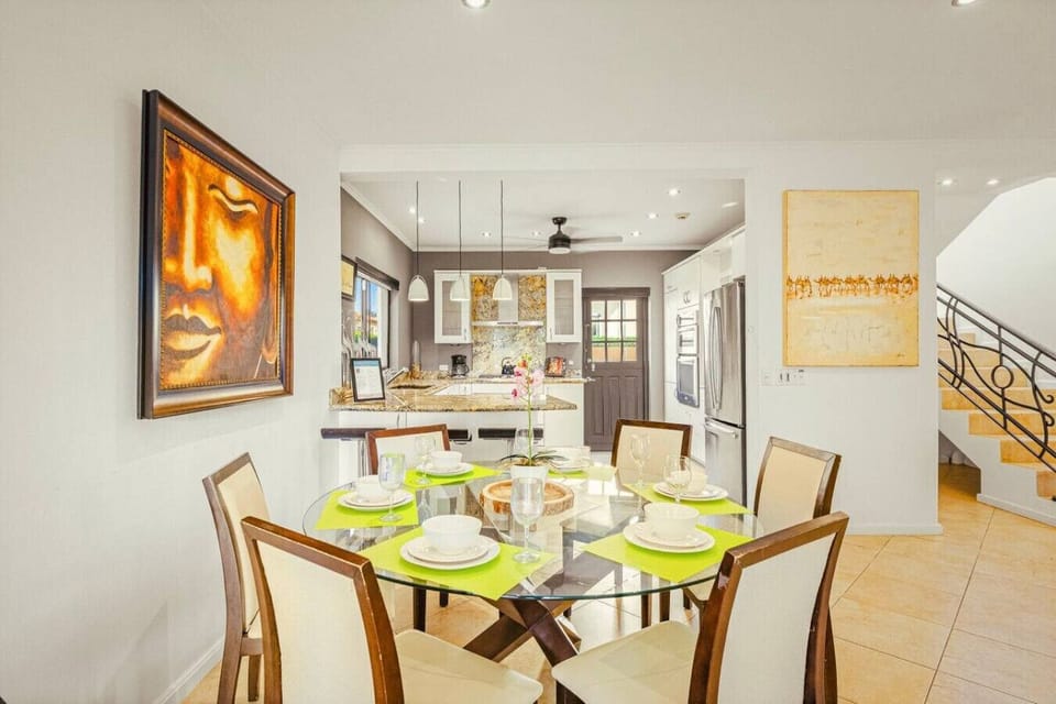 Warm lighting, sleek design, and artistic touches merge beautifully in this inviting dining and kitchen space.
