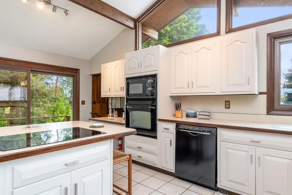 Bright and spacious kitchen featuring vaulted ceilings, modern appliances, and a cozy coffee station—perfect for cooking and gathering.