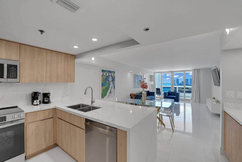 Fully equipped kitchen, view of dining area and living room, balcony access