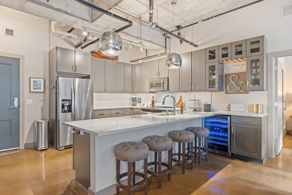 Your spacious kitchen features modern appliances, a large island with seating for four, and stylish industrial accents perfect for cooking and entertaining.