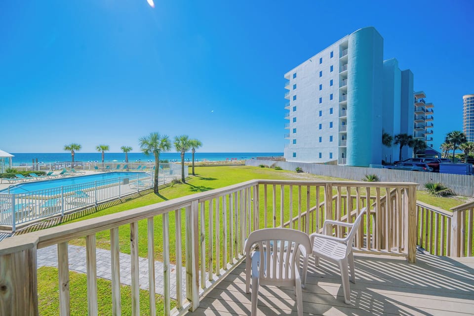 Relax on the private deck overlooking the sparkling pool and beachfront greenery, just steps from the coastline