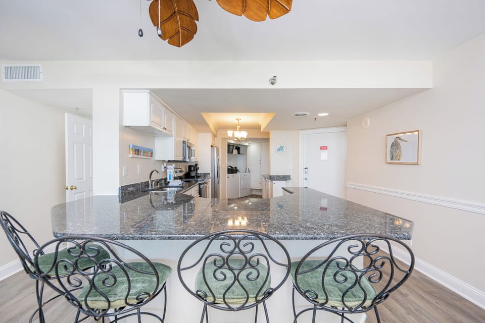 Spacious kitchen with granite countertops, stainless appliances, and stylish bar seating for a cozy dining experience