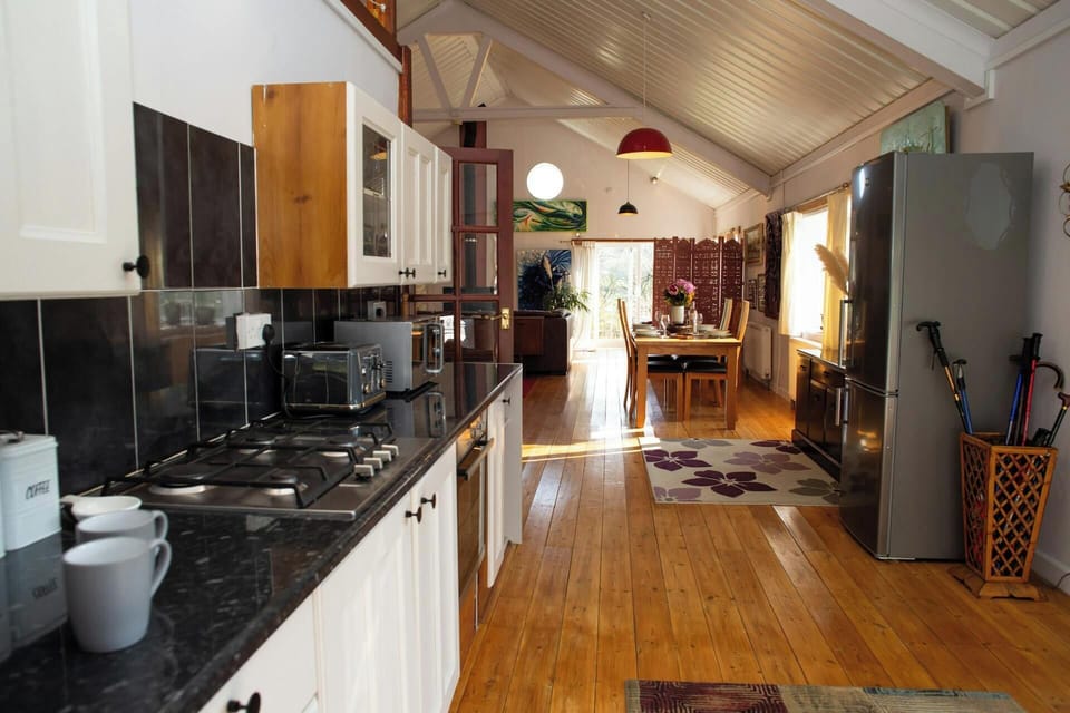 Kitchen interior with gas hob, countertop appliances and dining area in the distance