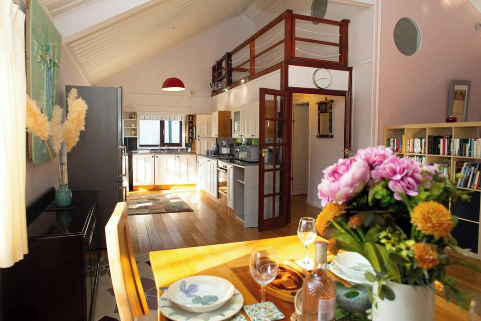 Open-plan kitchen and dining area with table set and flowers in the foreground