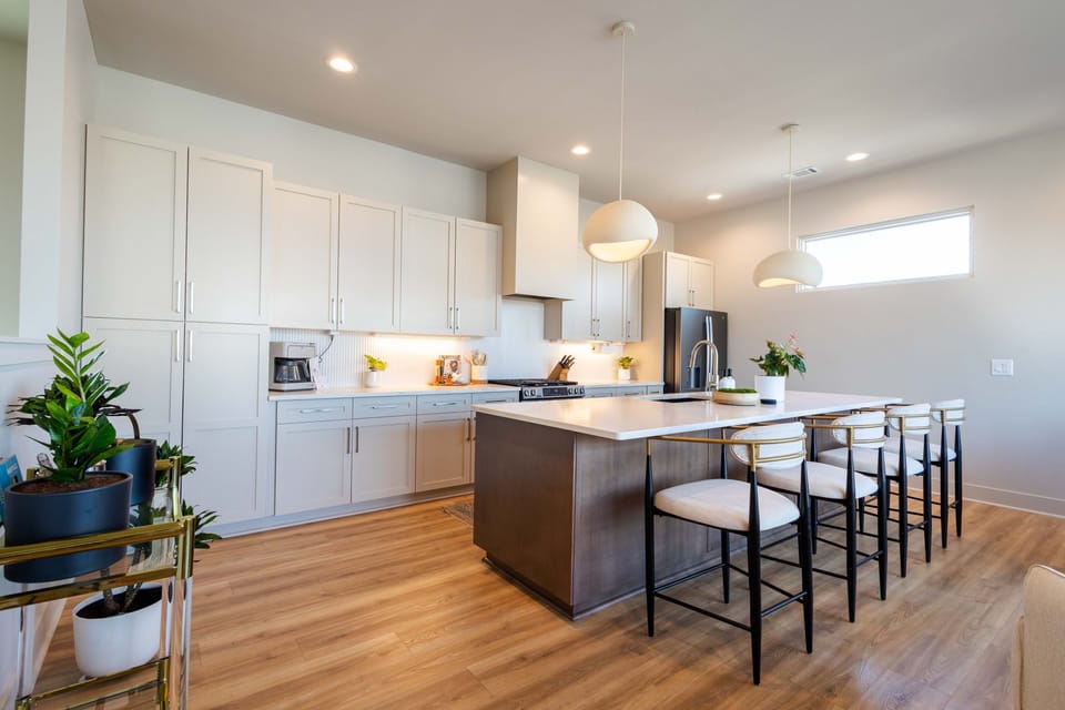 Bright modern kitchen featuring a large island, sleek finishes, and plenty of space to cook, dine, and unwind