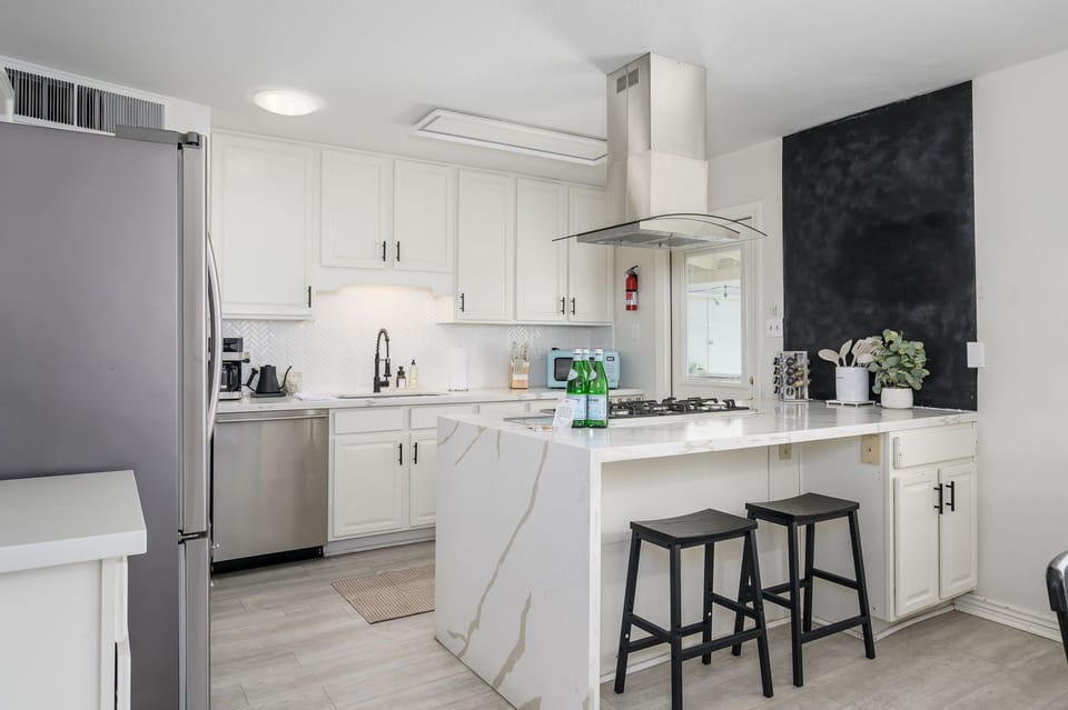 Enjoy cooking in this beautifully updated kitchen featuring sleek countertops, stainless steel appliances, and a spacious island with bar seating. Perfect for cooking family meals or gathering with friends over morning coffee.