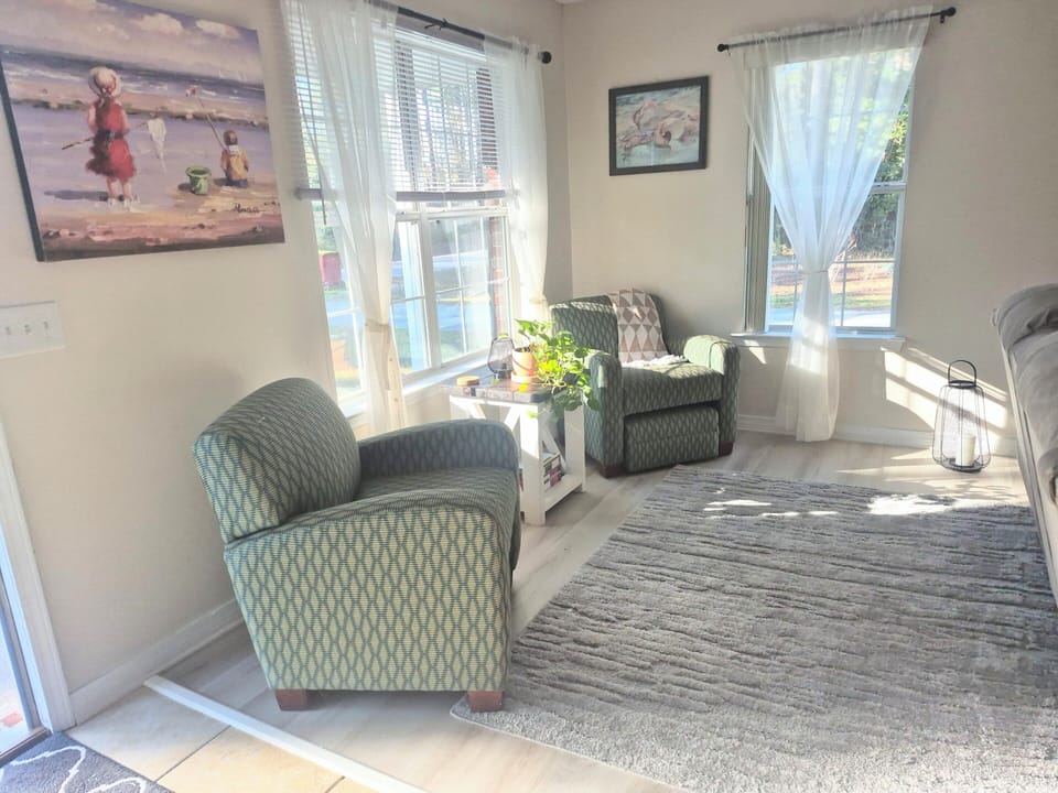 Front entrance of home by living room. Nice sunny sitting area with 2 pullout foot stools. 
