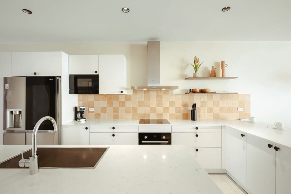 Fully equipped kitchen featuring modern appliances, cookware, essentials, and ample space for meal preparation