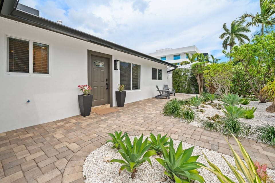 Welcoming entryway surrounded by tropical landscaping and beautiful curb appeal.