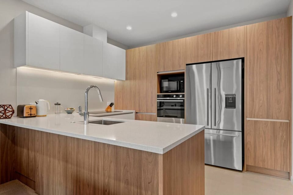 The kitchen has an oven, cooktop, dishwasher, microwave and fridge/freezer.
